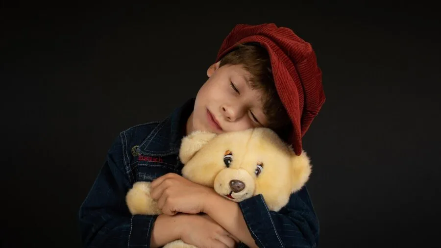 Infant playing with soft embroidered stuffed animal in bright nursery setting