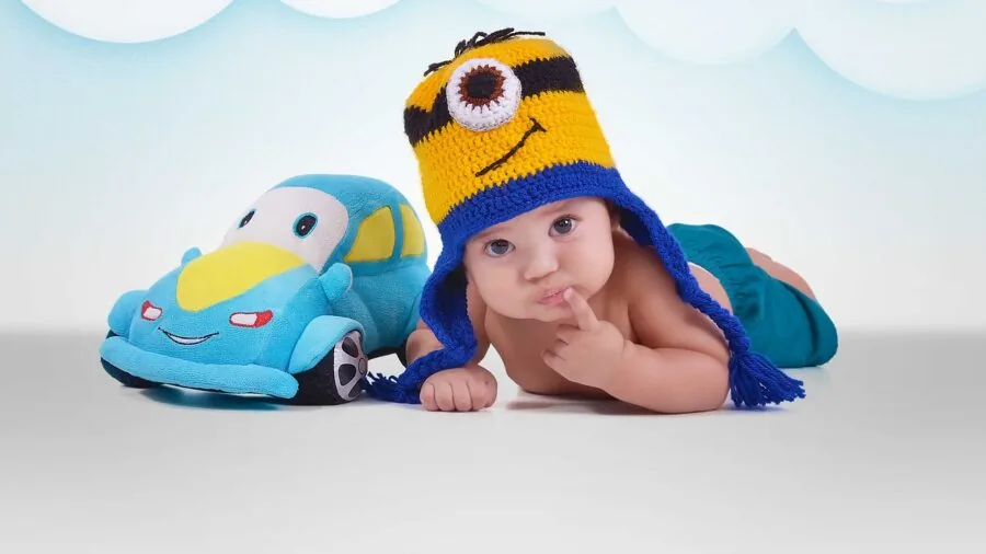Infant practicing rolling movements on a spacious play mat indoors