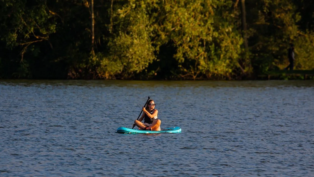 Inflatable paddle board floating on calm water with clear sky