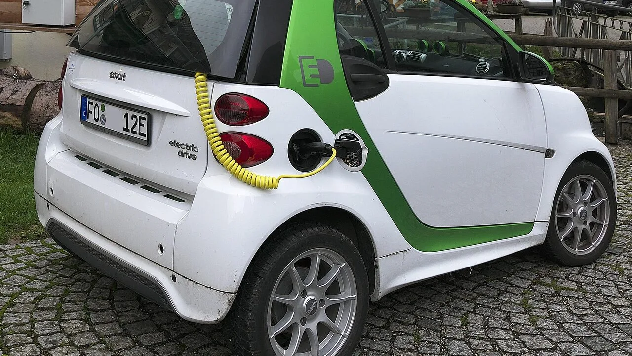 Jump starter connected to car battery terminals for engine starting