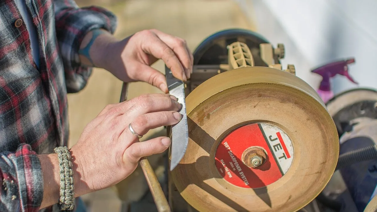 Knife sharpener tool being used to sharpen a kitchen knife on a countertop