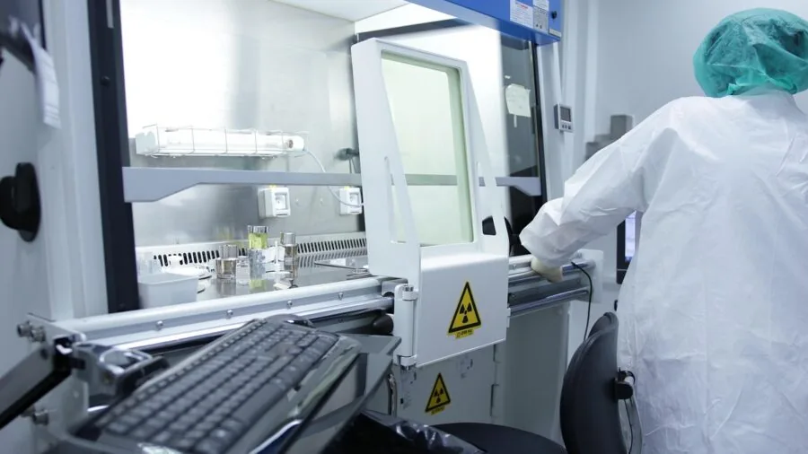 Lab professional using scientific instrument with focused concentration at workstation