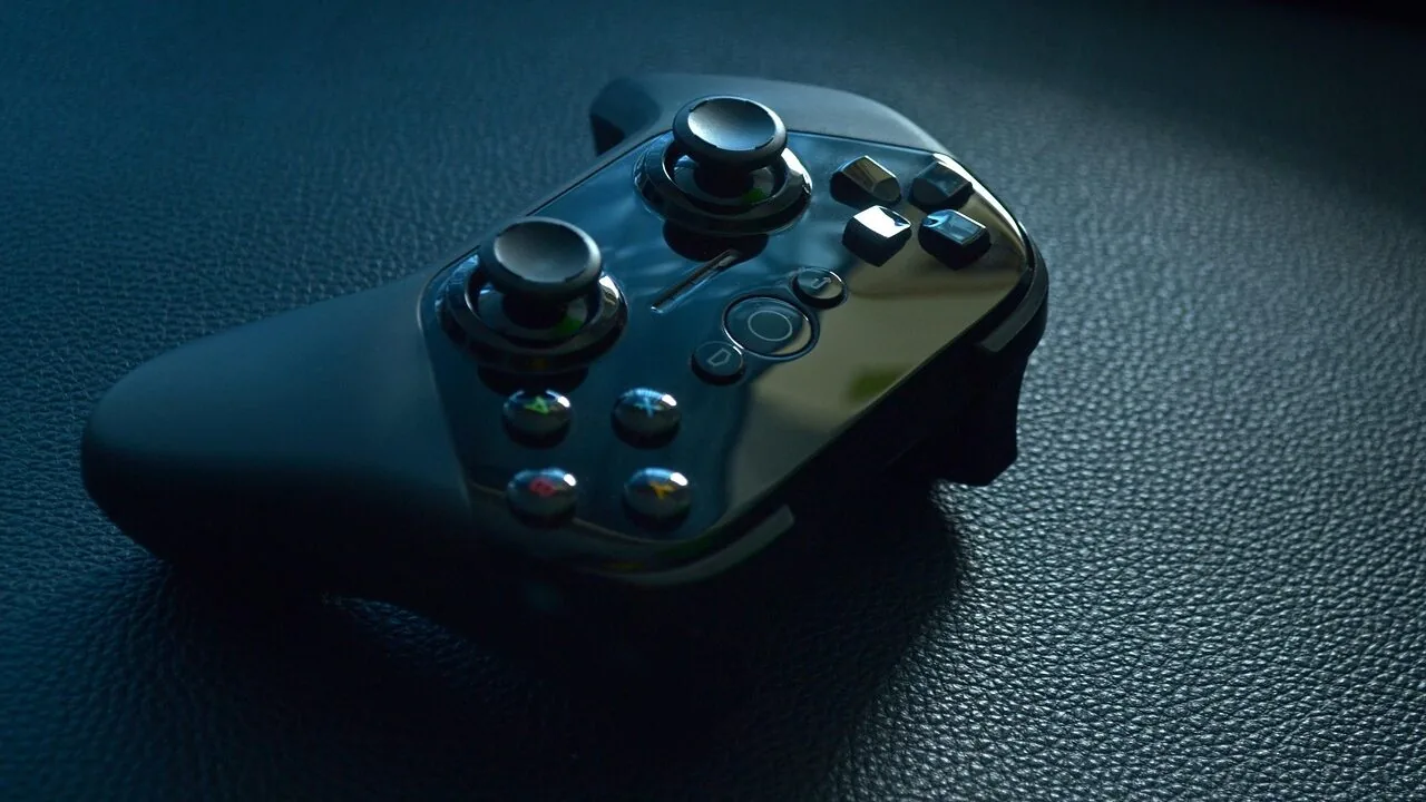 Large gaming TV displaying colorful game graphics with wireless controller in foreground