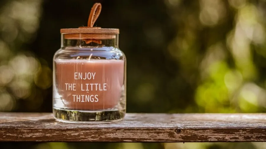 Lit candles in clear glass jars creating ambient lighting in a cozy home interior setting