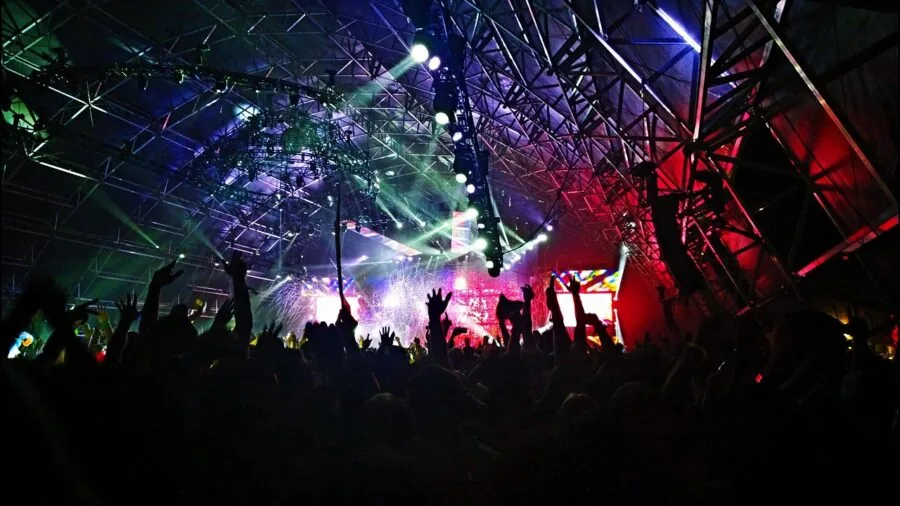 Live concert stage with bright lighting and sound equipment during energetic performance