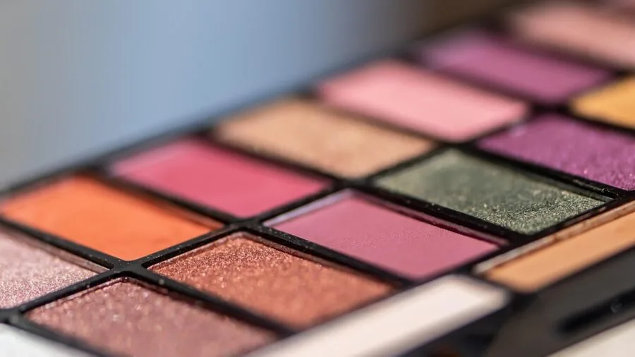 Makeup artist organizing cosmetic palettes in a travel bag for on-the-go beauty application