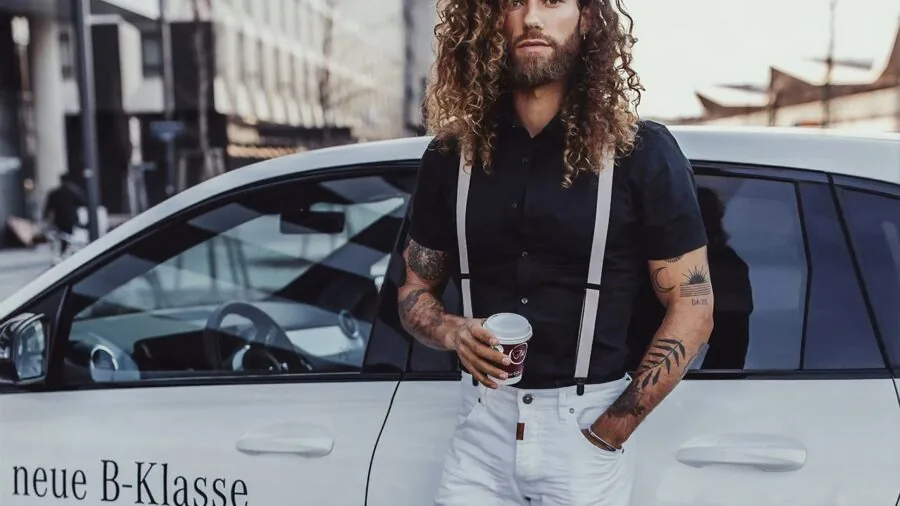 Man adjusting suspender straps while getting dressed in casual lifestyle setting