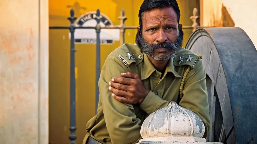 Man applying beard balm to his beard during morning grooming routine