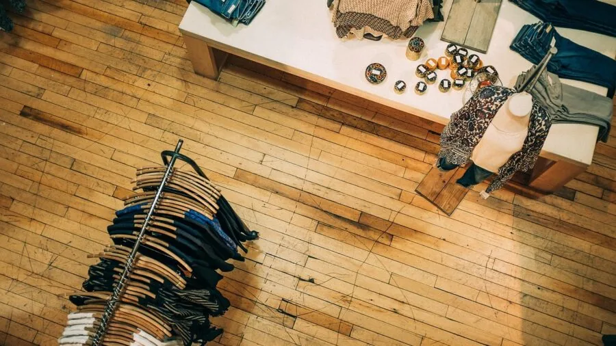 Man browsing clothing options in retail store, comparing bundle deals and pack sizes