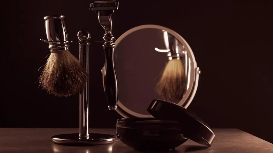 Man carefully grooming and trimming beard in bathroom mirror with natural lighting
