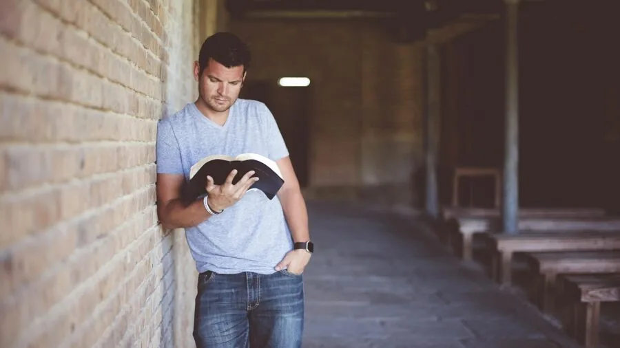 Man examining personal care product ingredients and labels with focused attention in natural lighting