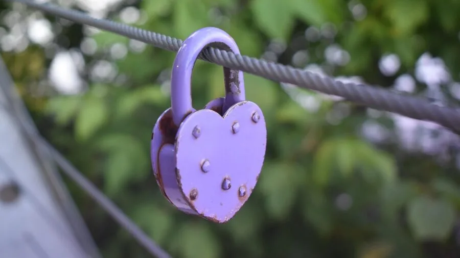 Man fastening metal clasp on wrist jewelry, demonstrating secure closure mechanism in natural light