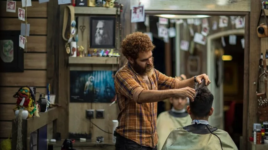 Man grooming and trimming beard in bathroom mirror as part of personal care routine