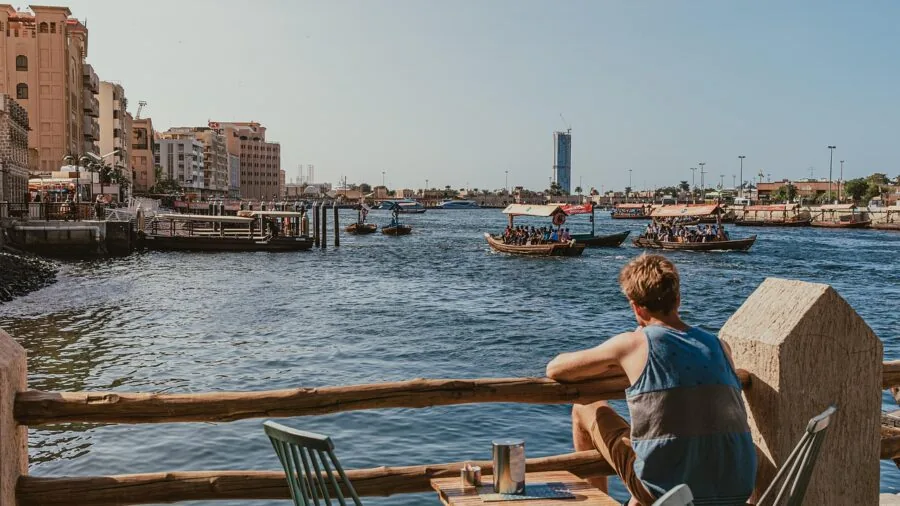 Man in casual boat shoes relaxing by the water on a sunny day, enjoying a leisurely waterfront moment
