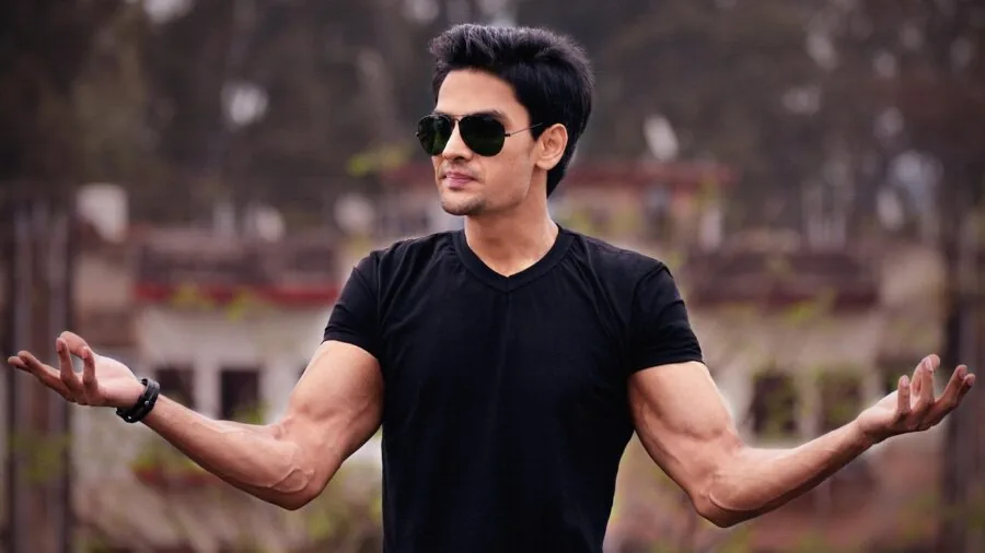 Man in casual shirt stretching arms, showing fabric tension and seam durability during movement