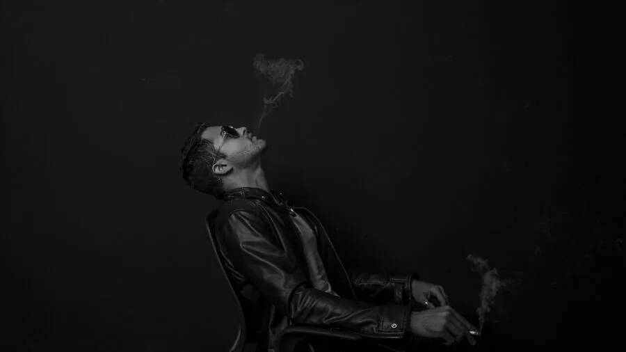 Man in classic black leather biker jacket styled with casual outfit, demonstrating iconic asymmetric zip silhouette
