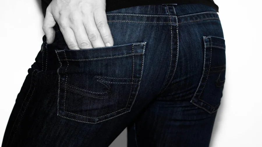 Man in classic cotton denim jeans standing outdoors showing natural fabric patina and texture