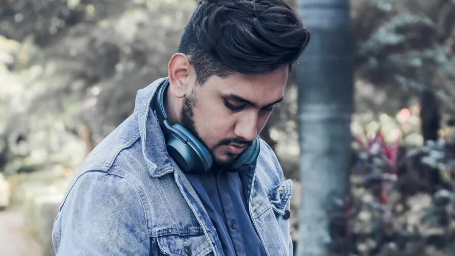 Man in denim jacket standing outdoors in natural daylight, showcasing real-world wear and fabric texture