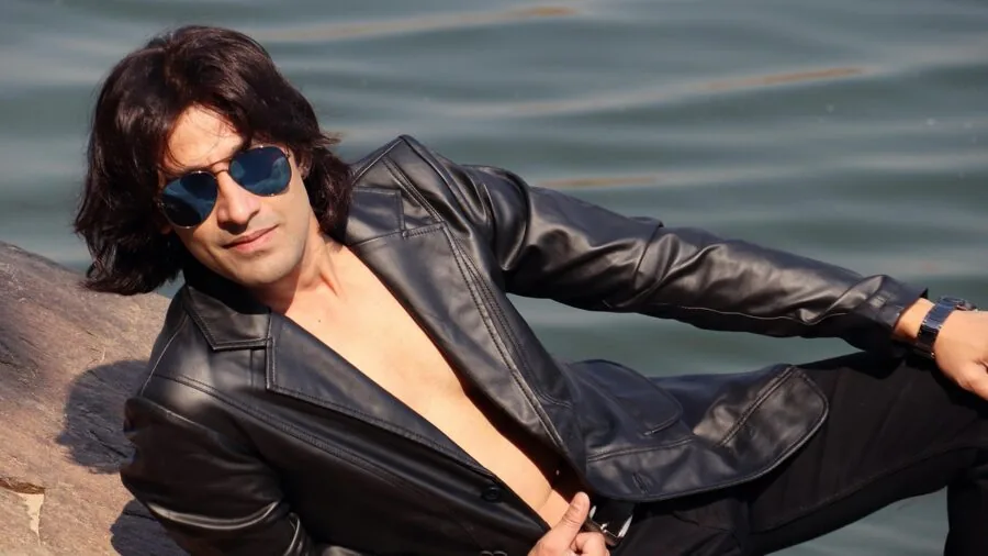 Man in premium leather jacket standing in natural outdoor setting, showcasing jacket quality and drape