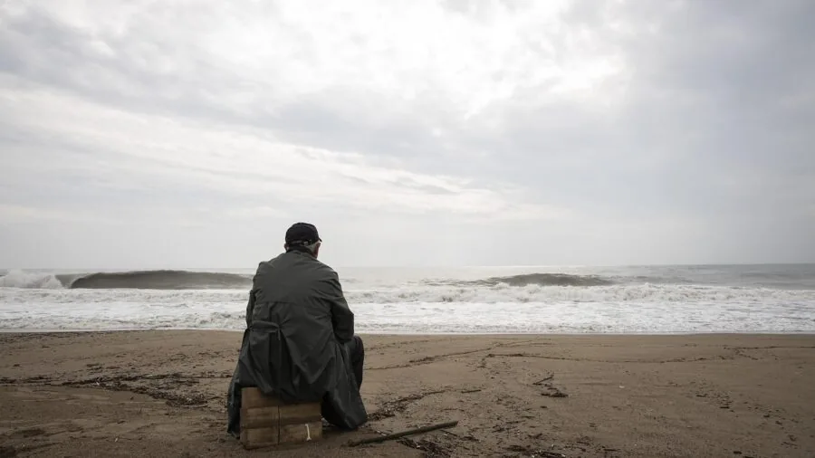 Man in puffer jacket standing in rainy outdoor conditions demonstrating weather resistance