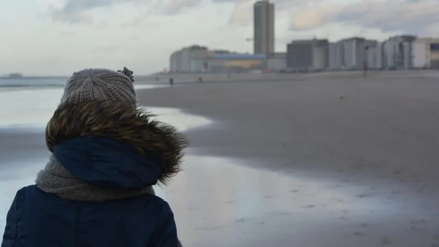 Man in winter coat with hood up walking in rainy weather, focusing on hood design and protection