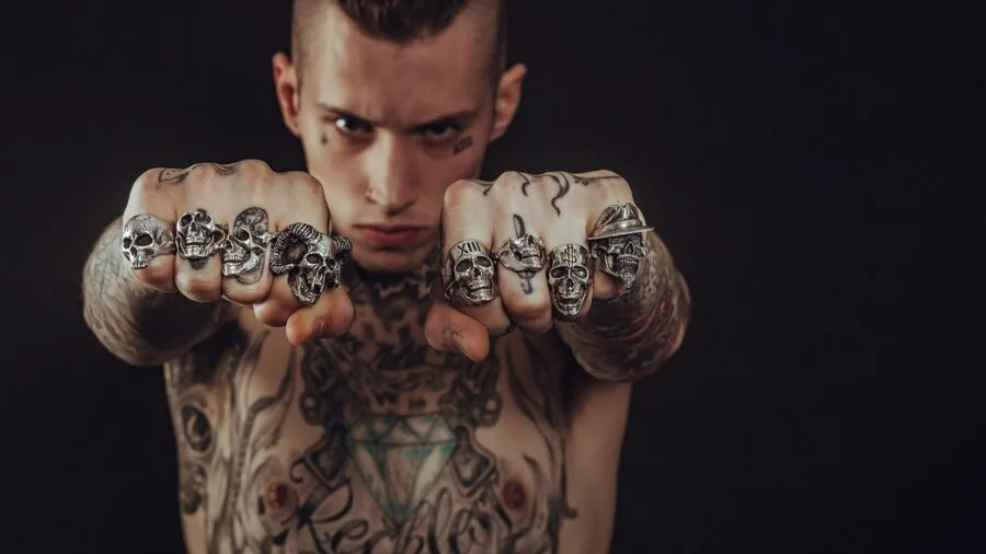 Man inspecting his hand and ring, checking for skin sensitivity or allergic reaction to metal