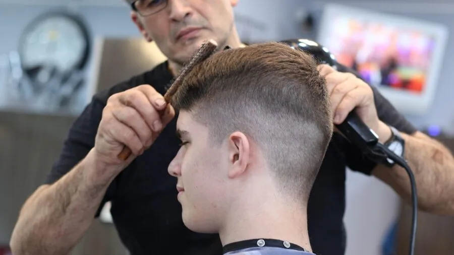Man reworking his hairstyle in bathroom mirror during daytime