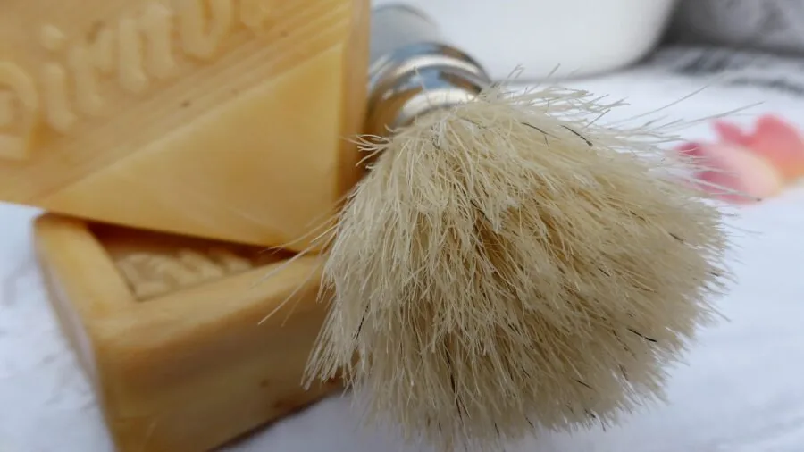Man shaving in bathroom mirror during morning grooming routine
