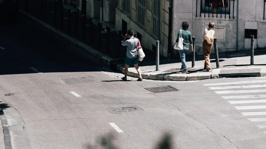 Man walking on wet city pavement, focusing on footwear traction and durability in real-world conditions