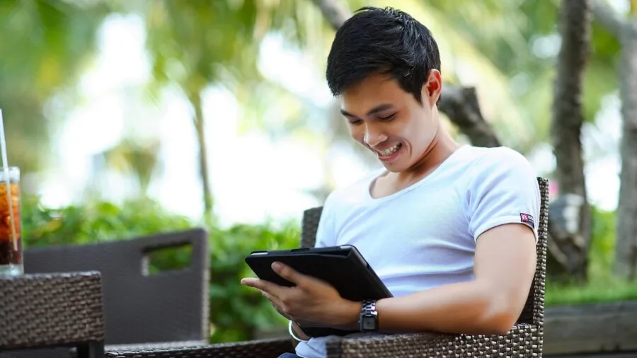 Mature adult adjusting settings on handheld device in dim lighting conditions