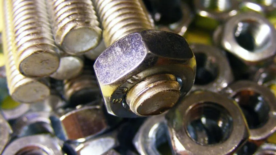 Mechanic applying force to loosen a stuck bolt with a wrench during vehicle repair