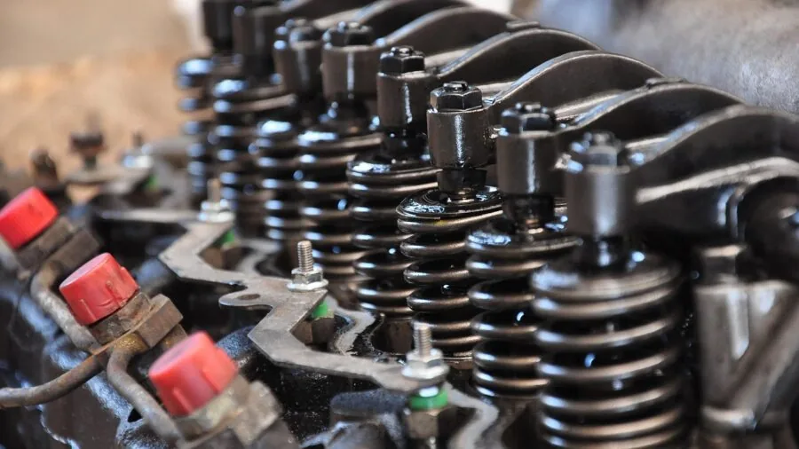 Mechanic carefully tilting and maneuvering engine during workshop lift installation