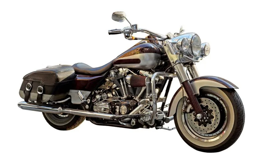 Mechanic inspecting classic motorcycle battery and electrical system in workshop setting