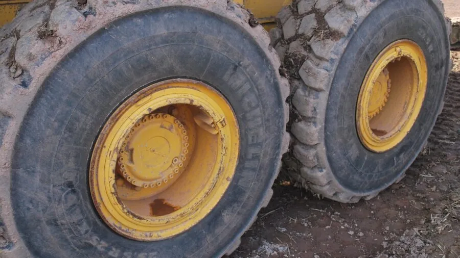 Mechanic inspecting vehicle wheel lug nuts and threading for proper fit and compatibility