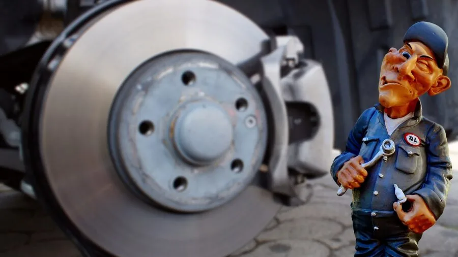Mechanic performing diagnostic reset on vehicle computer system in professional auto repair shop