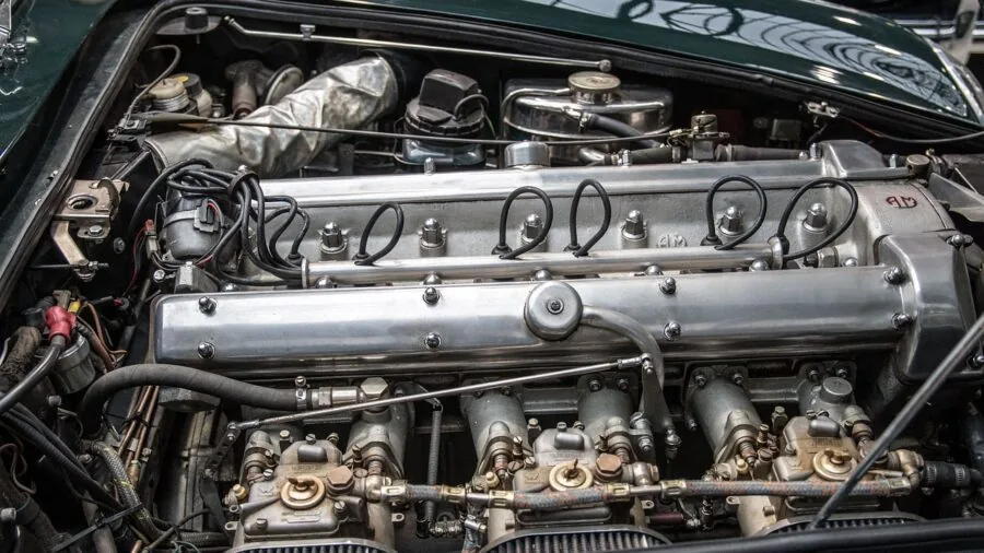 Mechanic performing maintenance work in a cramped engine bay with limited space and tools
