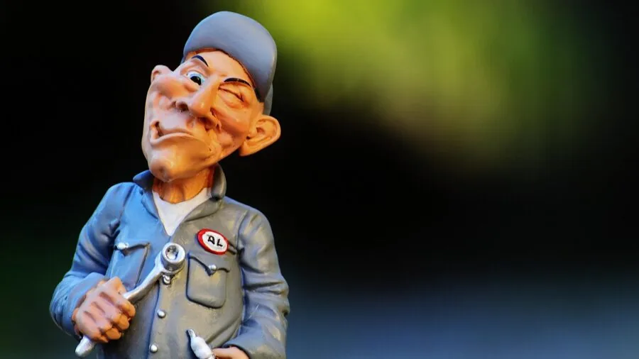 Mechanic using diagnostic tool to update vehicle software in professional auto shop