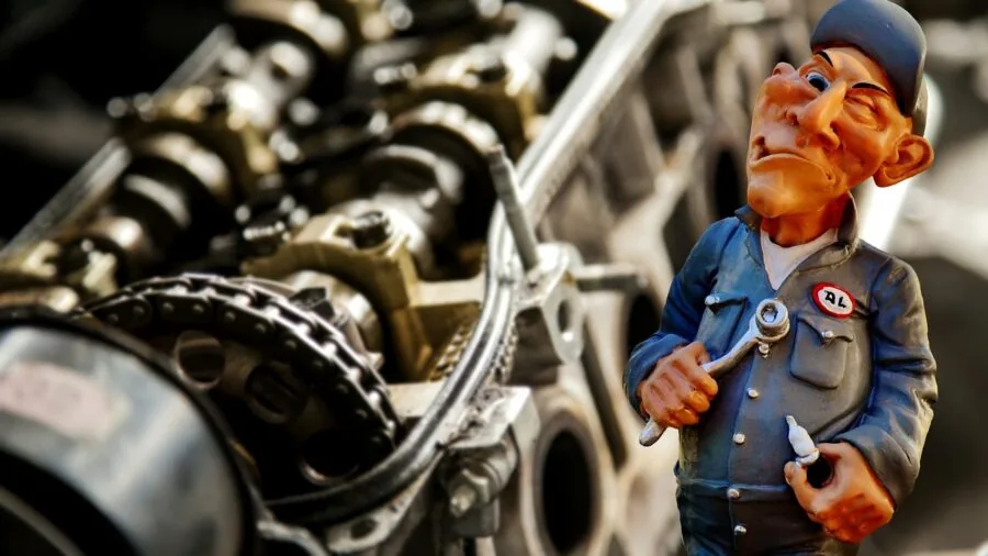 Mechanic using tools on car undercarriage in workshop setting