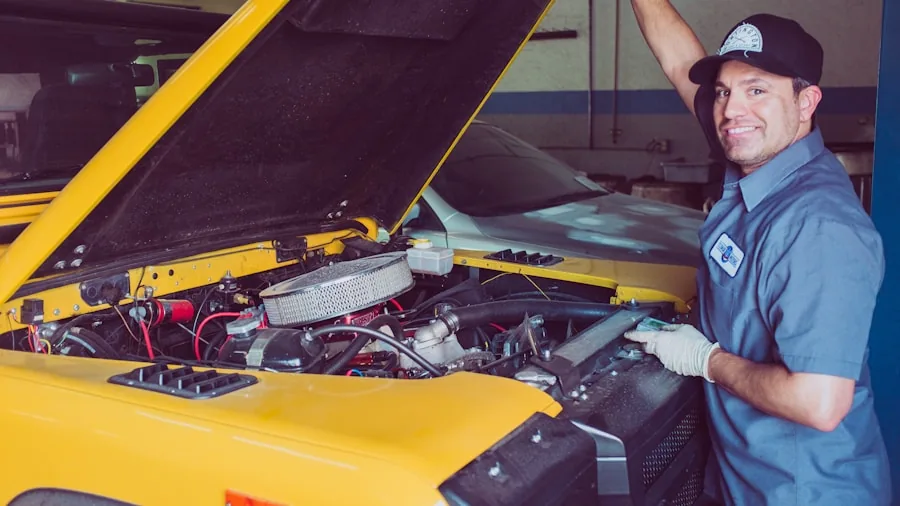 Mechanic using tools to work on car engine in garage workshop