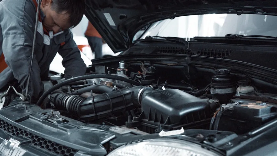 Mechanic using tools while working on a car engine in a workshop