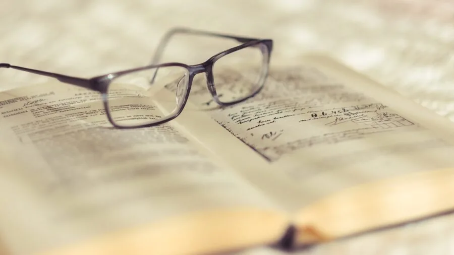 Middle-aged person reading book up close, demonstrating proper reading distance and posture