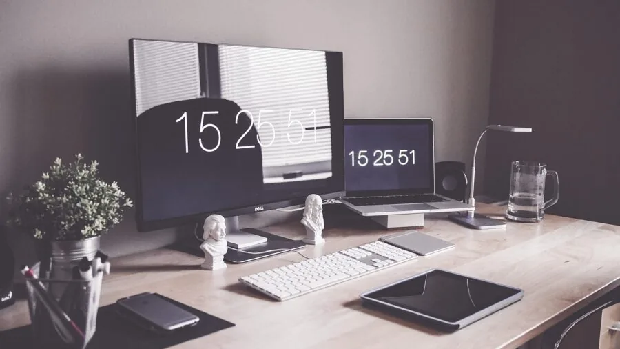 Minimalist desk with metallic laptop stand, organized workspace, natural lighting from window