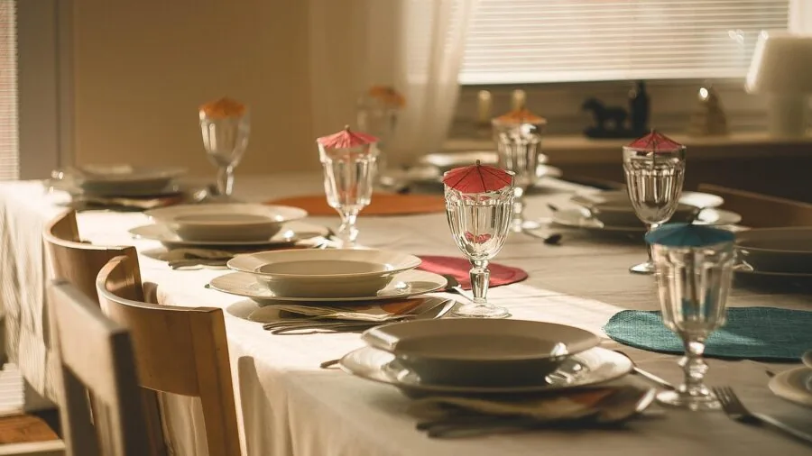 Minimalist table setting with warm-toned ceramic dishes and organic shapes on a natural wood surface