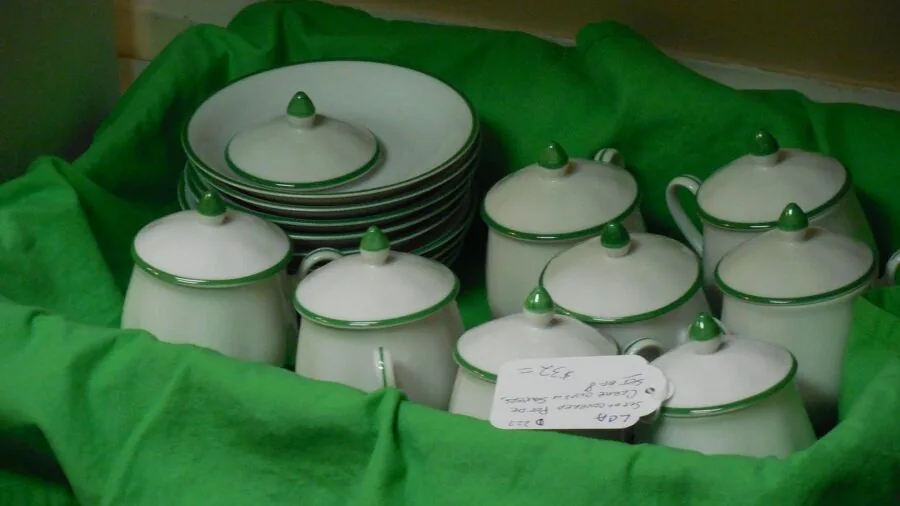 Minimalist white ceramic bowls arranged on a dining table with place settings and natural lighting