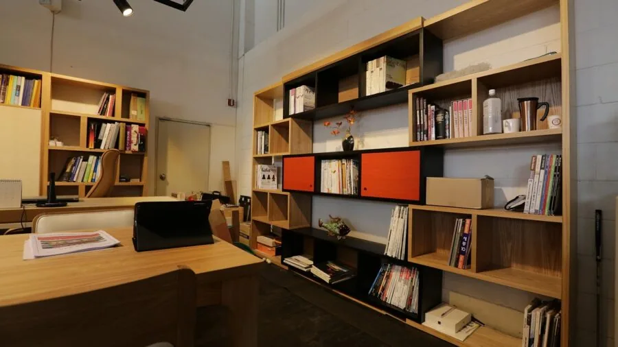 Minimalist wooden shelving on white wall in contemporary living room with natural light