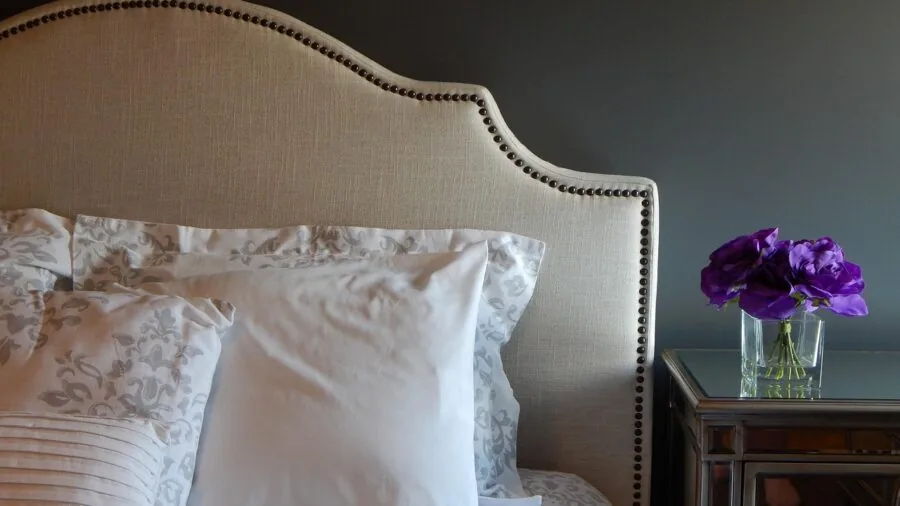 Modern bedroom with built-in headboard storage in compact room design