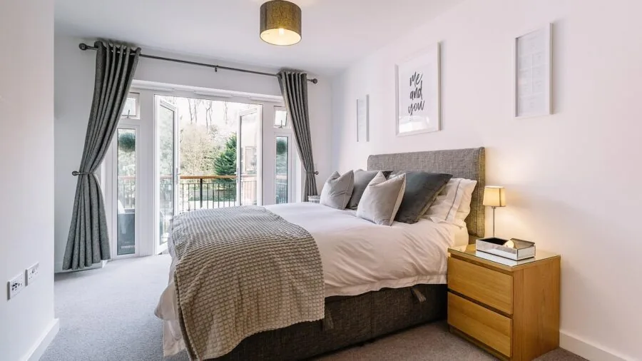 Modern bedroom with clean lines, neutral colors, and simple wall-mounted headboard above bed