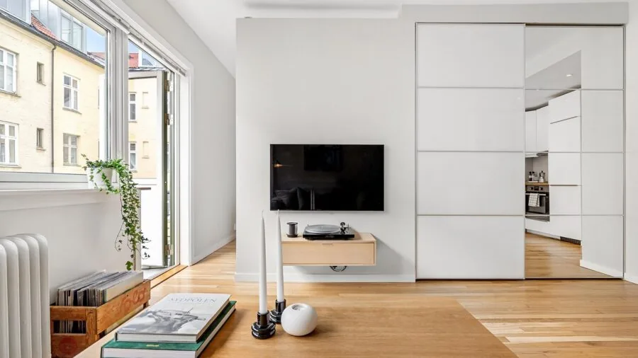 Modern flat-panel TV mounted on wall in contemporary living room with comfortable seating