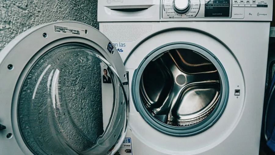 Modern laundry room with washer hookup plumbing and electrical outlet installation