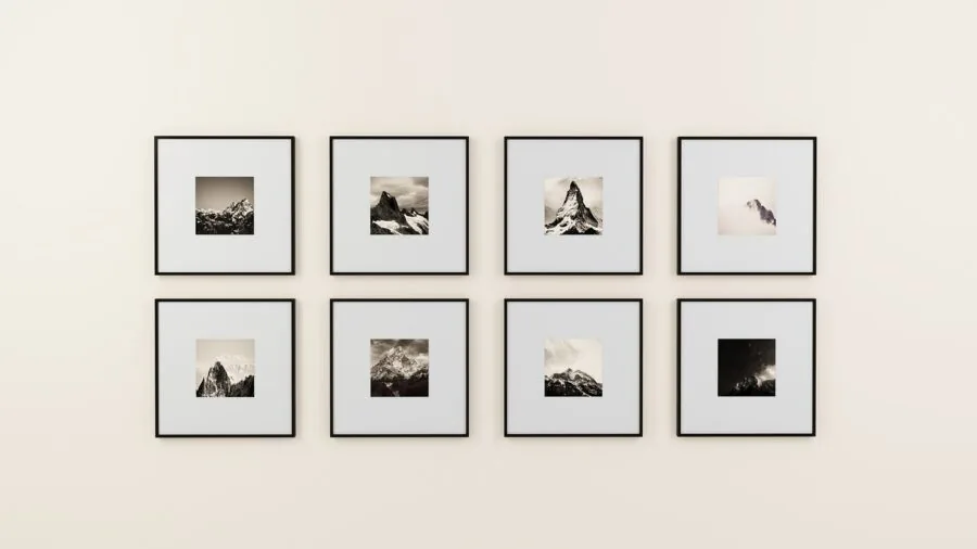 Modern living room with multiple framed photos arranged on white wall in gallery style layout